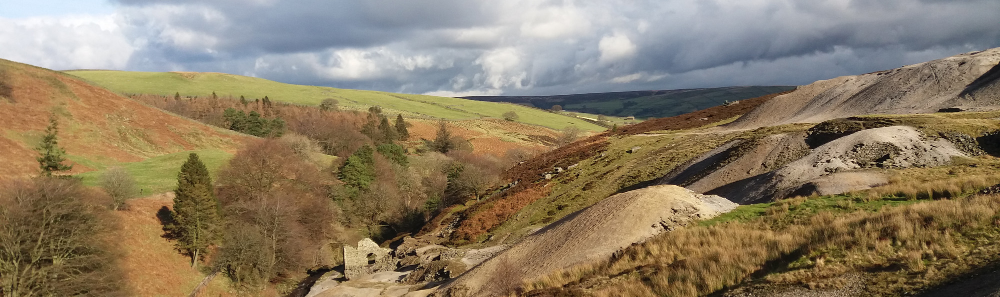 Countryside view with ruins of stone building at the bottom of a valley