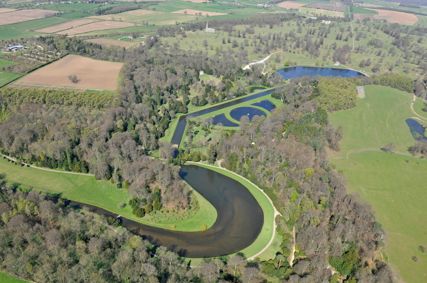Looking down on Studley Royal Water Garden surrounded by trees and green fields