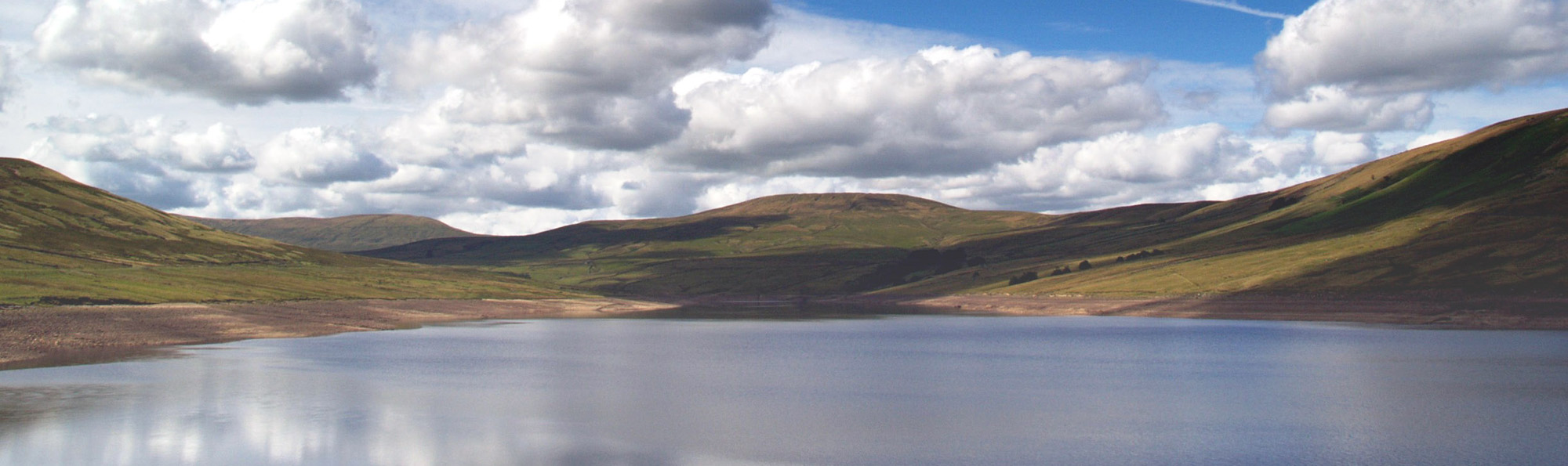 large body of water with green hills behind