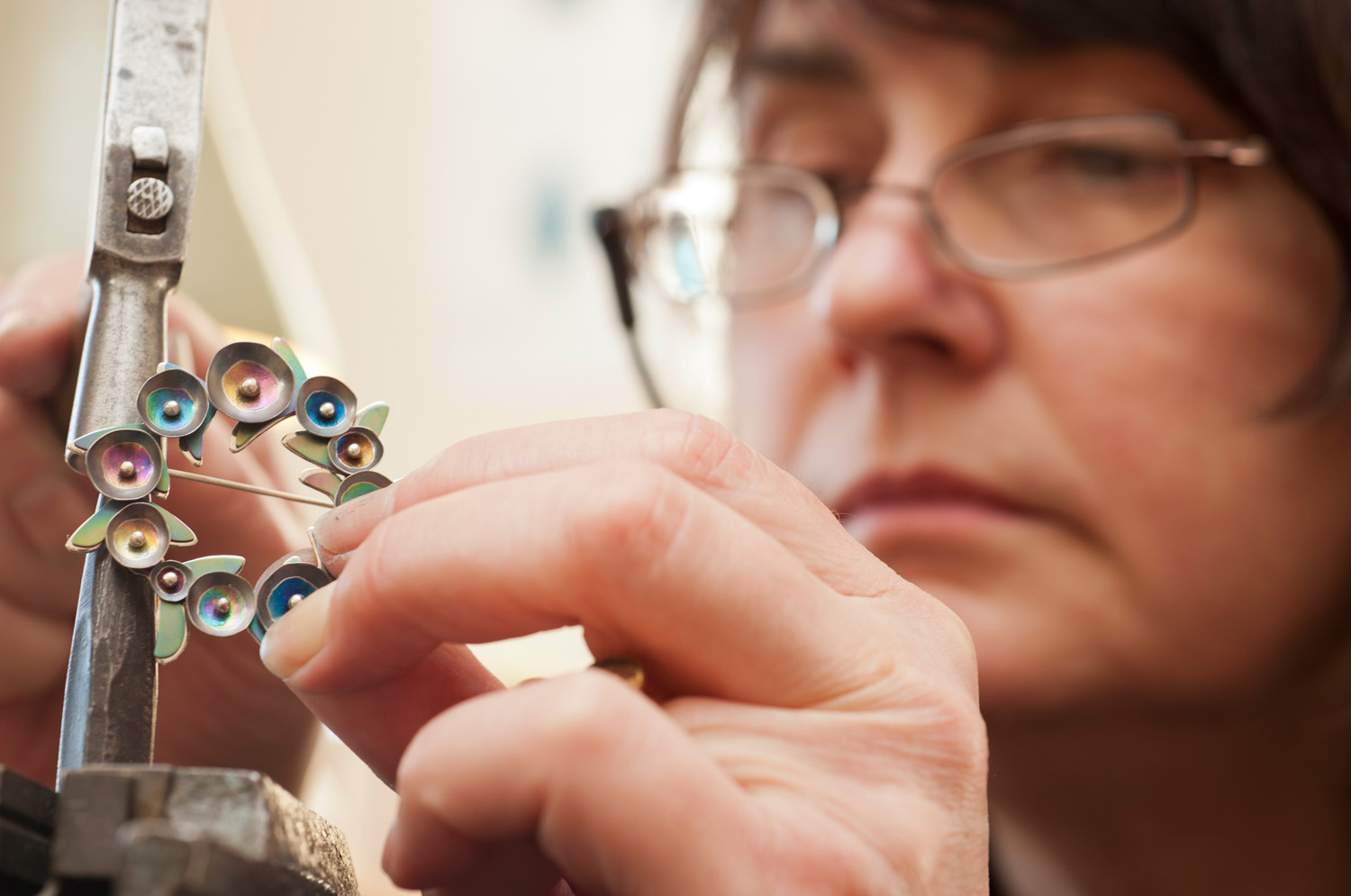 Close up of woman creating metal broach