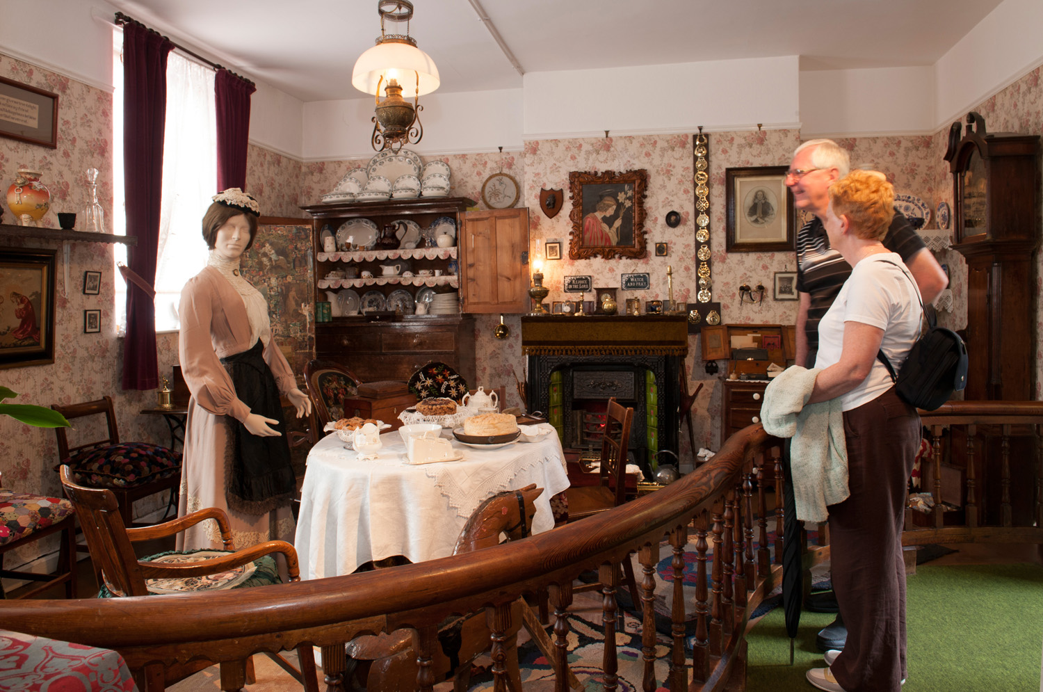 Two adults looking at a museum display of a Victorian room