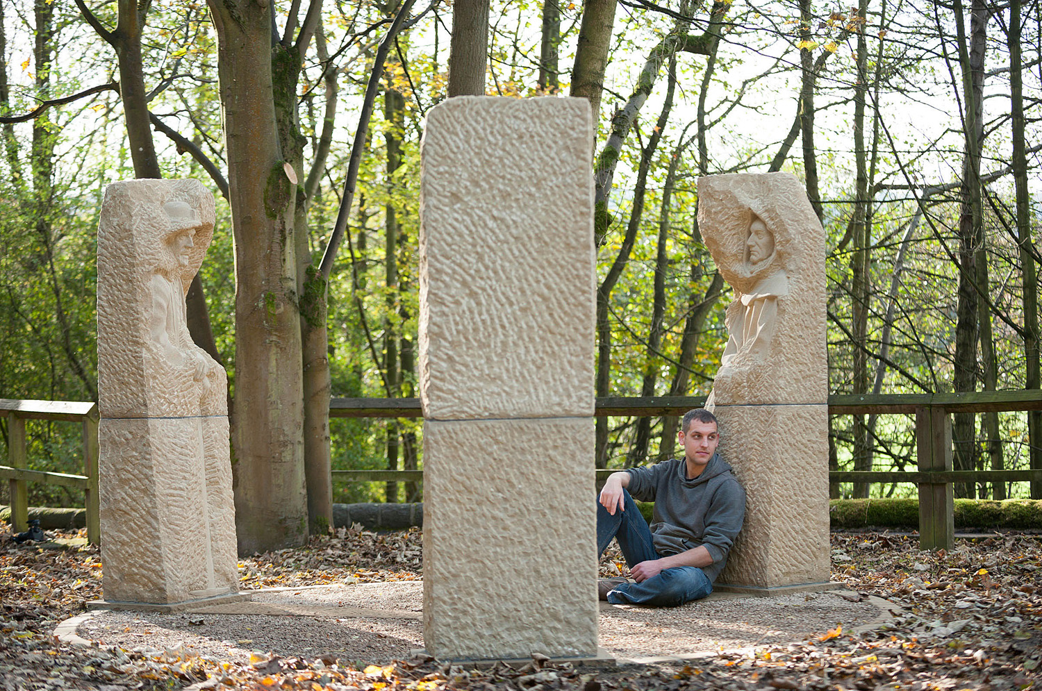 Man sitting down leaning on stone sculpture