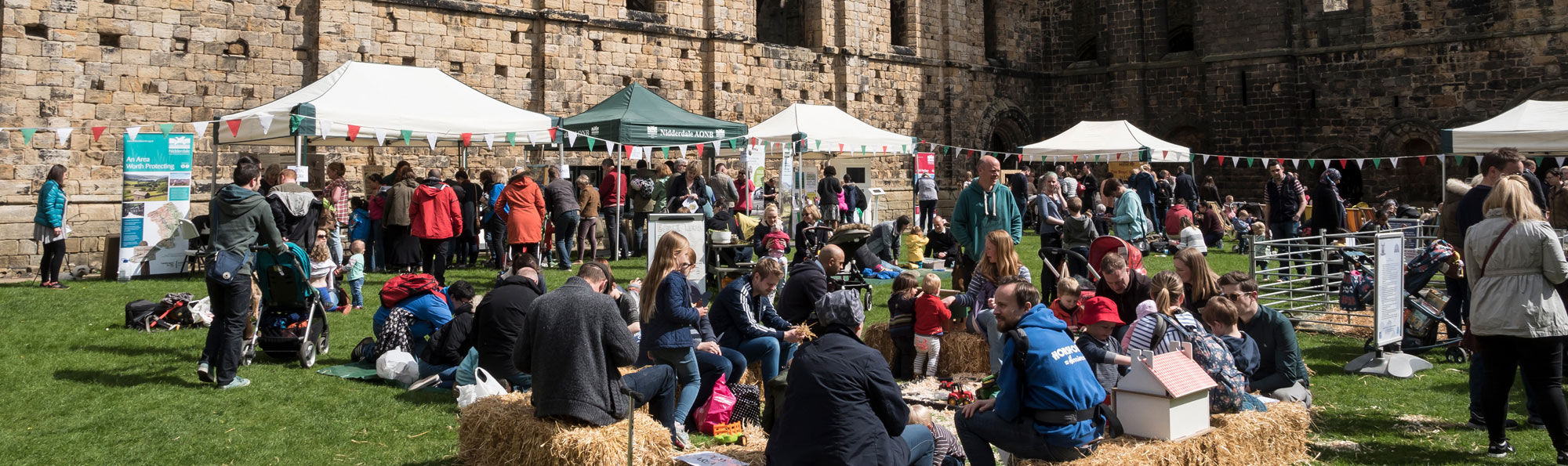 People at an event with gazebos and bunting